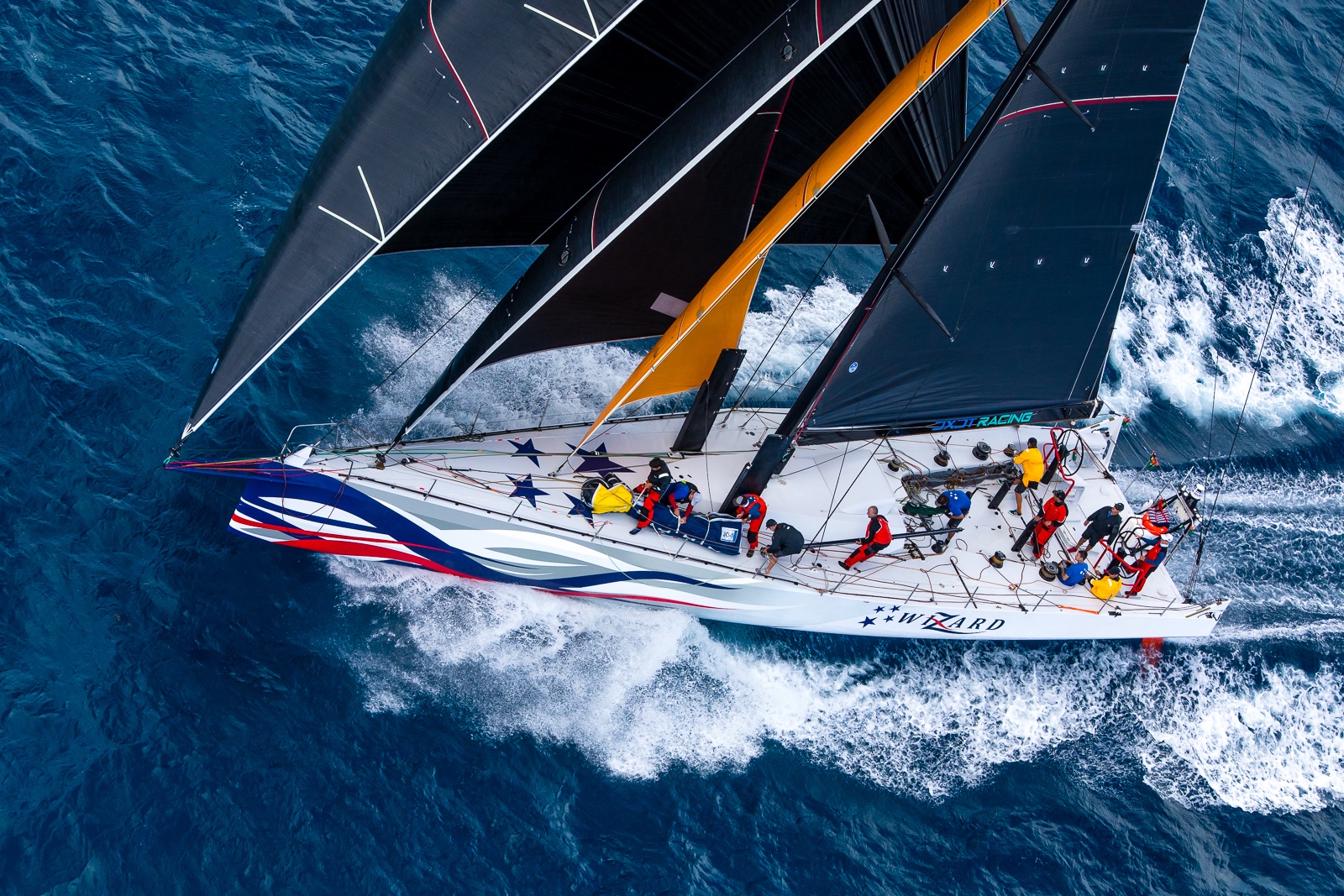 Close-up of a racing yacht and crew working through rough water
